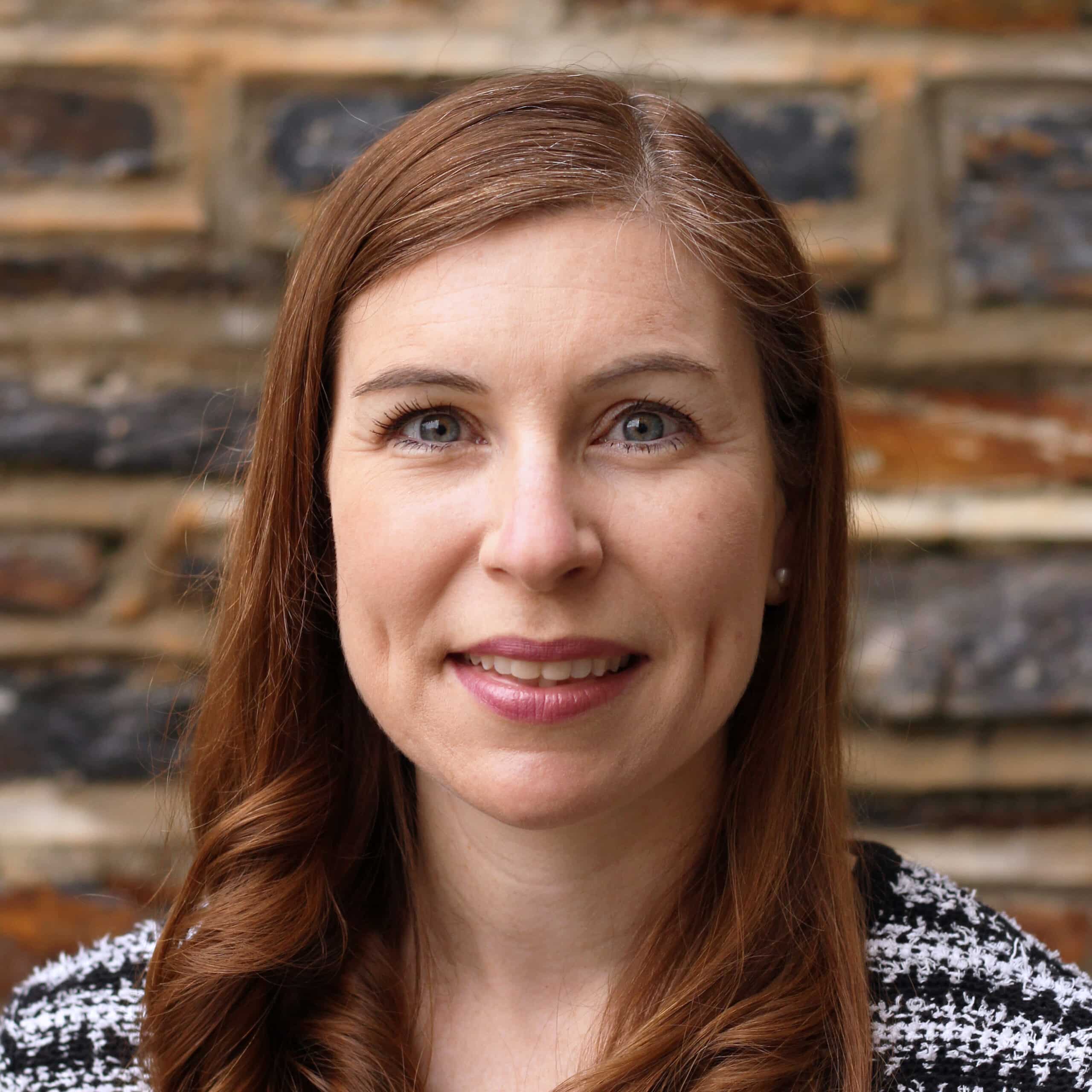 Bridget Kerwin smiles in front of a brick building on Duke University's campus.