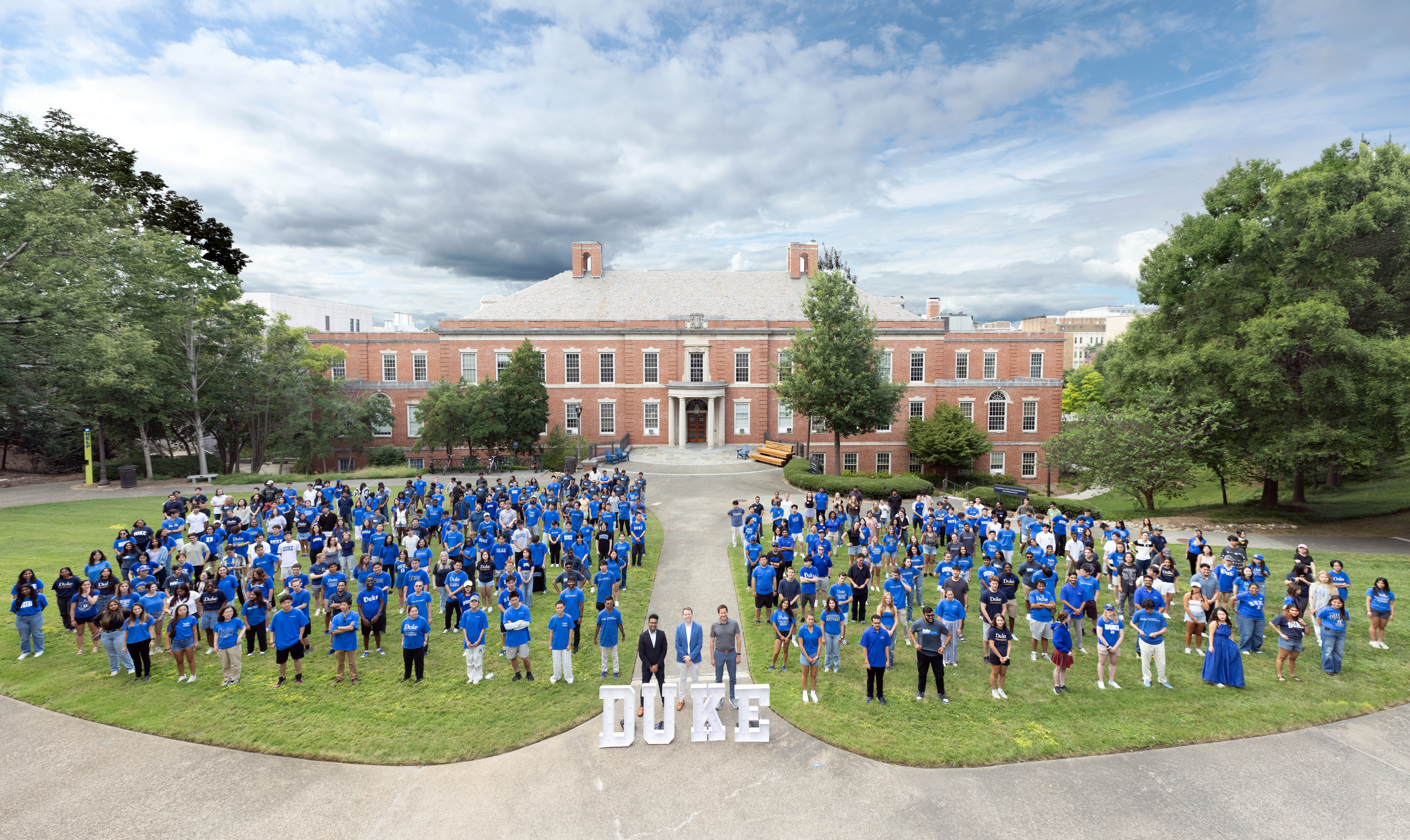 Incoming master's students pose on the Harrington Quad in front of the Hudson Building.