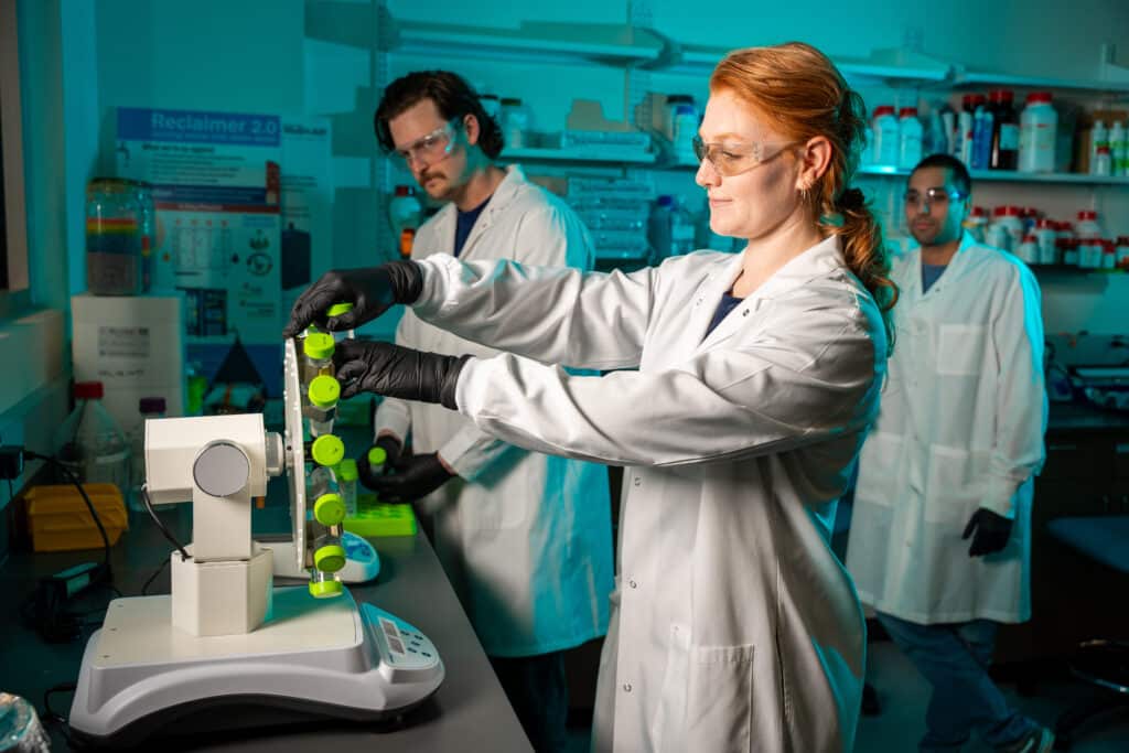 Julia Darcy and research associates load a centrifuge in the lab