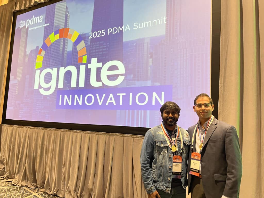 two people standing in front of a giant projection screen