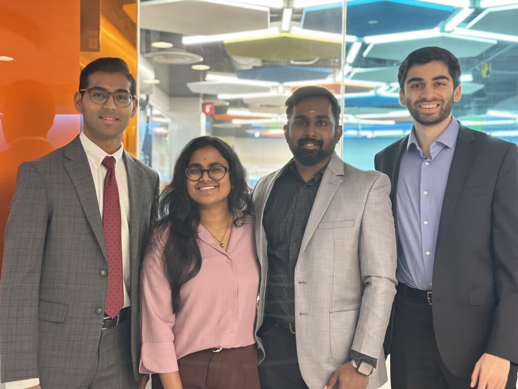Four people standing together in a colorful room
