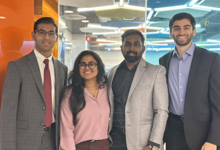 Four people standing together in a colorful room