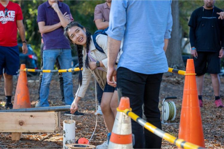 A student bends over a geothermal well at Duke University