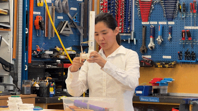 Student giving a demonstration of a teaching model made out of PVC pipe in the Design Pod lab space
