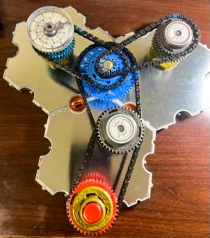 A toy set consisting of gears connected by roller chains.