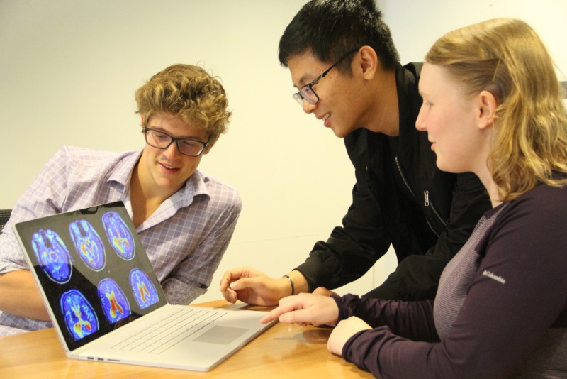 Members of the Duke Applied Machine Learning Club examine FMRI images of the brain 